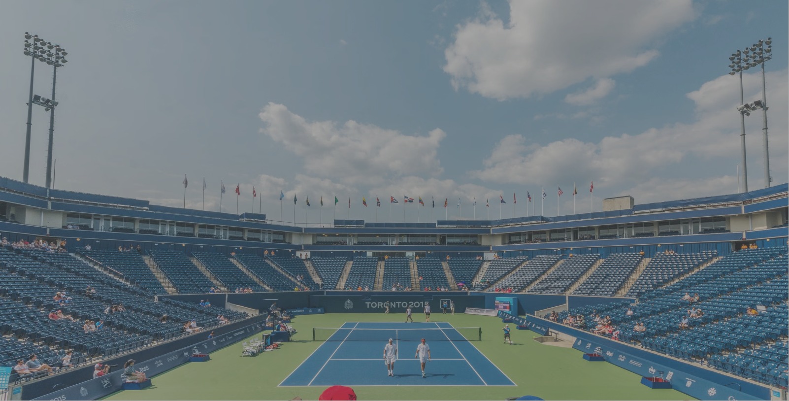 Outdoor tennis stadium under a blue sky